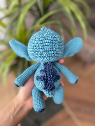 Handmade crochet Stitch Toy, amigurumi plush with a custom name on a leather label. Perfect as a personalized gift for kids, featuring a blue alien design.