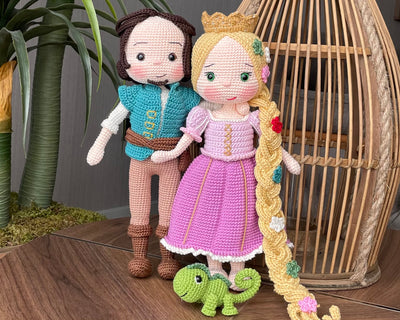 Handmade crocheted Rapunzel and Flynn Rider Dolls with Pascal, featuring intricate details such as Rapunzel's long braided hair and floral accents. These are customizable with a name on a leather label, perfect as a fairy tale-themed gift or decor.