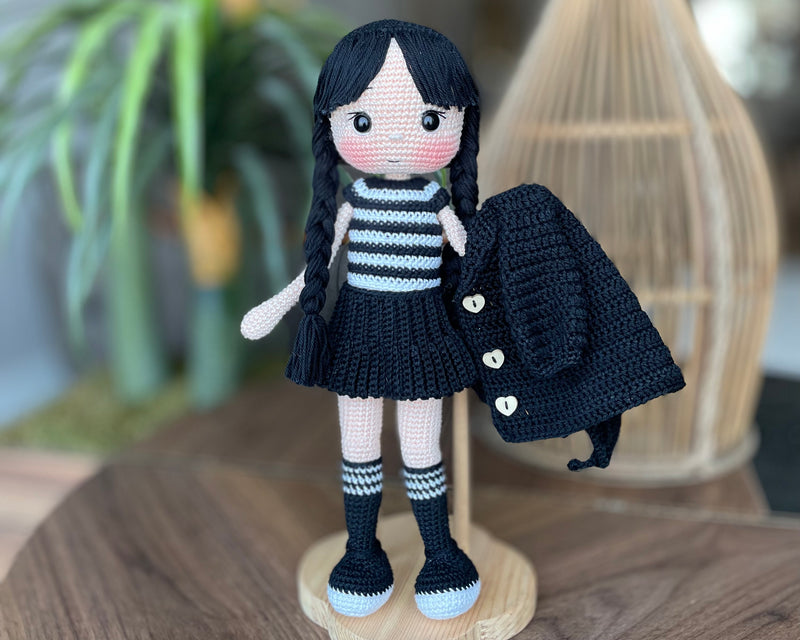 Handmade Wednesday Addams Doll with black braids, a black dress, and a spooky themed accessory, crocheted using the amigurumi technique and personalized with a name. Perfect for kids and Halloween Gift.