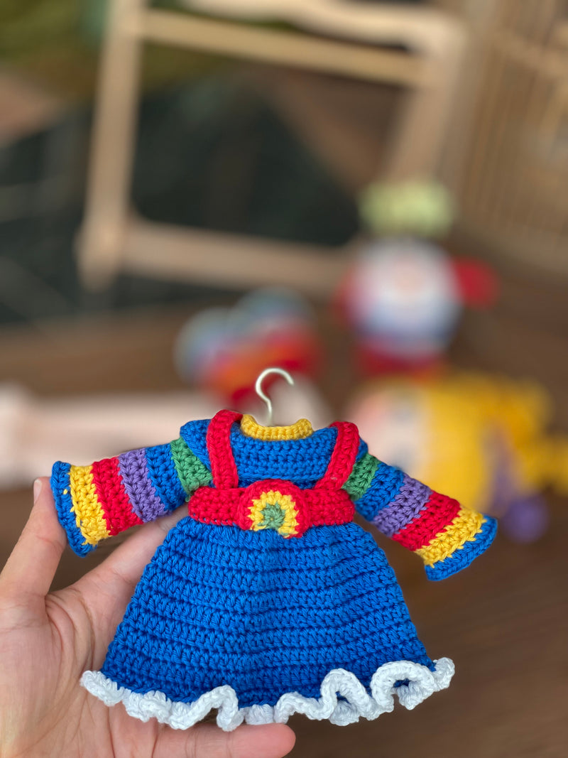 A handmade Rainbow Brite Girl Doll with vibrant yellow hair, holding Twink, a colorful star plush toy. The doll is crocheted using the amigurumi technique and personalized with a custom name on a leather label.