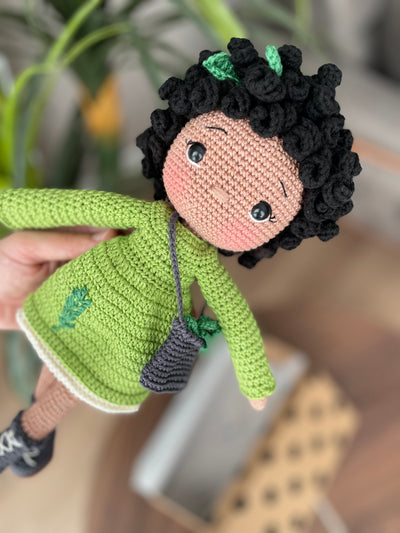 Handmade Rosemary dressed curly girl doll with a green outfit, crafted using amigurumi crochet technique, personalized with a name on a leather label, ideal for gifts.