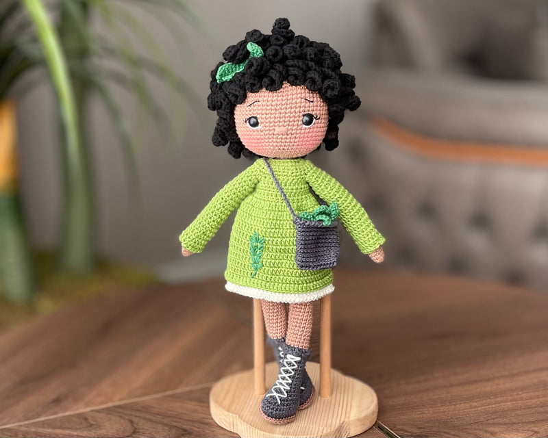 Handmade Rosemary dressed curly girl doll with a green outfit, crafted using amigurumi crochet technique, personalized with a name on a leather label, ideal for gifts.