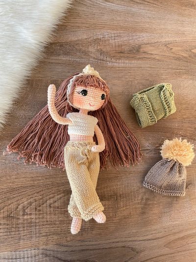 A handcrafted Green Cardigan Cool Girl Doll with long brown hair, wearing a stylish green cardigan and beanie, crocheted using the amigurumi technique, and personalized with a custom name on a leather label.