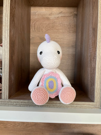 Handmade unicorn dinosaur toy crocheted with soft yarn in pastel colors, featuring customizable name on a leather label, perfect for kids and baby gifts.