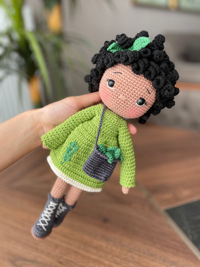 Handmade Rosemary dressed curly girl doll with a green outfit, crafted using amigurumi crochet technique, personalized with a name on a leather label, ideal for gifts.