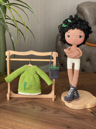 Handmade Rosemary dressed curly girl doll with a green outfit, crafted using amigurumi crochet technique, personalized with a name on a leather label, ideal for gifts.