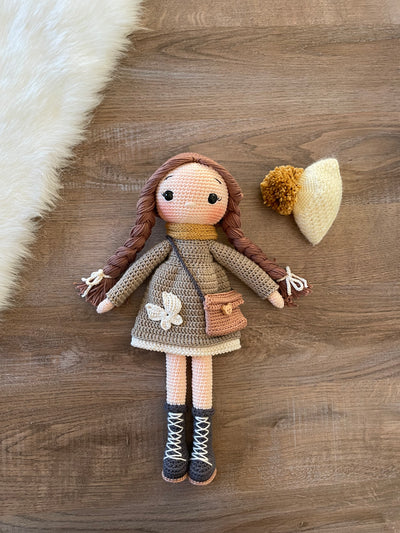 Handmade crochet Khaki Green Winter Girl Doll, featuring long braids, a cozy winter outfit, and personalized with a name on a leather label. Perfect gift for kids.