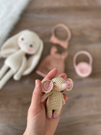 Handmade crocheted amigurumi bunny rabbit doll with a small mouse toy, dressed in pink, made of 100% cotton, customizable with a name on a leather label, perfect for nursery decor.