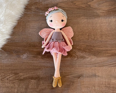 Handmade Fairy Doll with delicate wings, wearing a pink dress and floral headband, made with 100% cotton yarn, customizable with a name on a leather label, perfect for unique girl gifts and imaginative play.