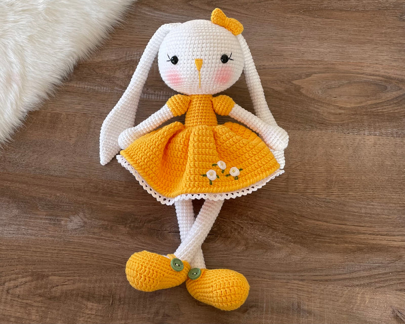 Handmade Yellow Dressed Bunny Rabbit Toy crocheted with amigurumi technique, featuring a cute yellow dress with embroidered flower details and customizable name on a leather label. Perfect for kids and baby gifts.