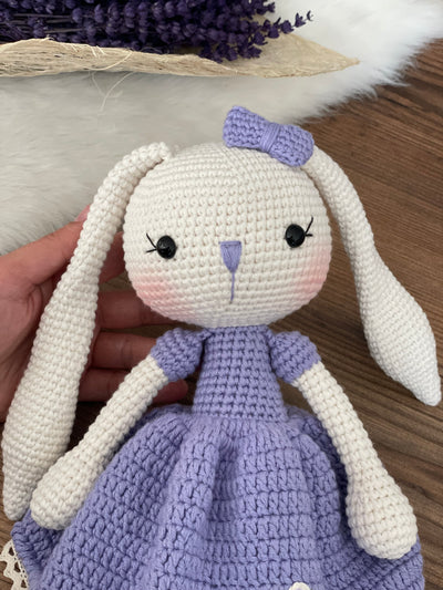 Handmade crochet Lilac Dressed Bunny Rabbit Toy, featuring long ears, a lilac dress with floral details, and personalized with a name on a leather label. Perfect for gifting.