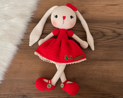 Handmade Red Dressed Bunny Rabbit Toy crocheted with amigurumi technique, featuring a cute red dress with embroidered christmas tree details and customizable name on a leather label. Perfect for kids and baby gifts.