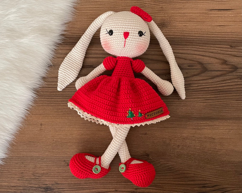 Handmade Red Dressed Bunny Rabbit Toy crocheted with amigurumi technique, featuring a cute red dress with embroidered christmas tree details and customizable name on a leather label. Perfect for kids and baby gifts.