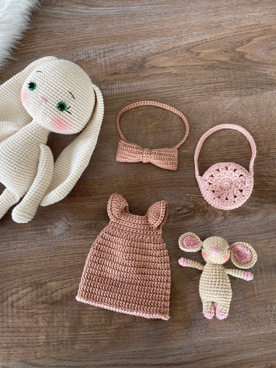 Handmade crocheted amigurumi bunny rabbit doll with a small mouse toy, dressed in pink, made of 100% cotton, customizable with a name on a leather label, perfect for nursery decor.