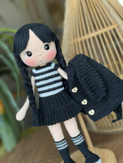 Handmade Wednesday Addams Doll with black braids, a black dress, and a spooky themed accessory, crocheted using the amigurumi technique and personalized with a name. Perfect for kids and Halloween Gift.