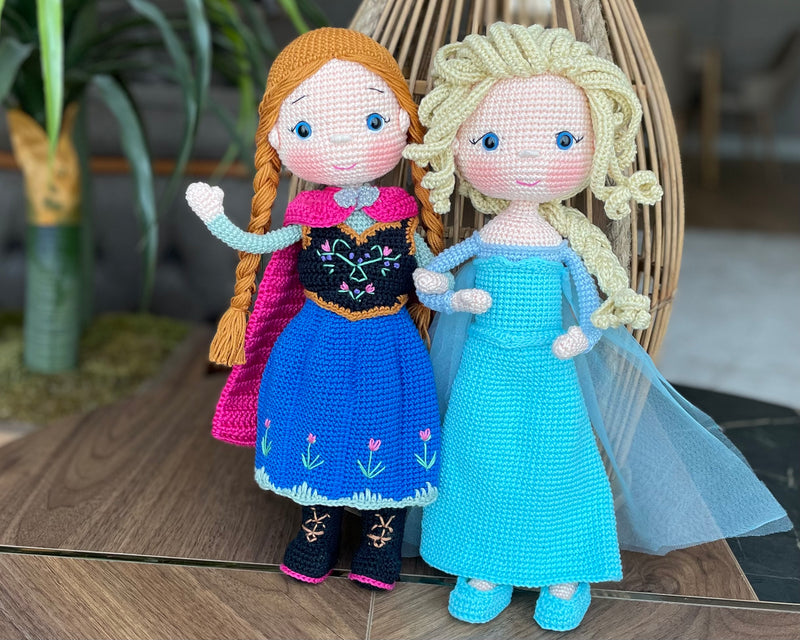 Handmade crocheted amigurumi dolls of Elsa and Anna, inspired by Frozen. Detailed with colorful outfits, perfect for custom name personalization or gifting.