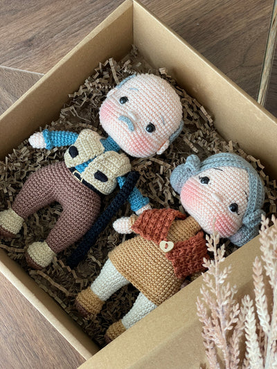 Handmade Grandma and Grandpa Dolls, crocheted using the amigurumi technique, customized with a name on a leather label, lying inside a gift box, perfect for gifts and family decor.