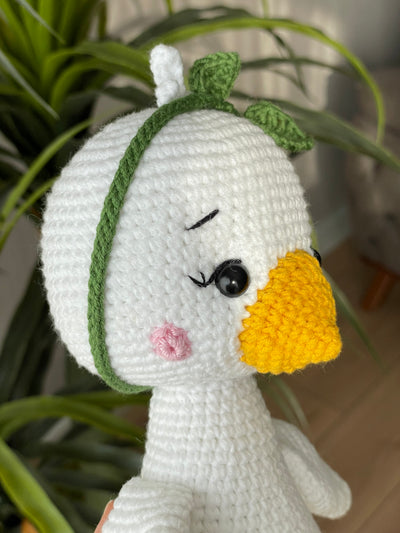 Handmade crocheted Duck Toy with a yellow beak and feet, customizable with a name on a leather label, crafted using amigurumi techniques. A perfect gift for kids or as nursery decor.