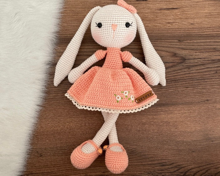 Handmade Salmon Dressed Bunny Rabbit Toy crocheted with amigurumi technique, featuring a cute salmon dress with embroidered flower details and customizable name on a leather label. Perfect for kids and baby gifts.