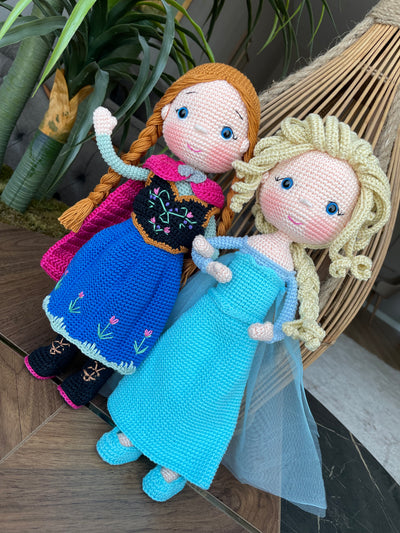 Handmade crocheted amigurumi dolls of Elsa and Anna, inspired by Frozen. Detailed with colorful outfits, perfect for custom name personalization or gifting.