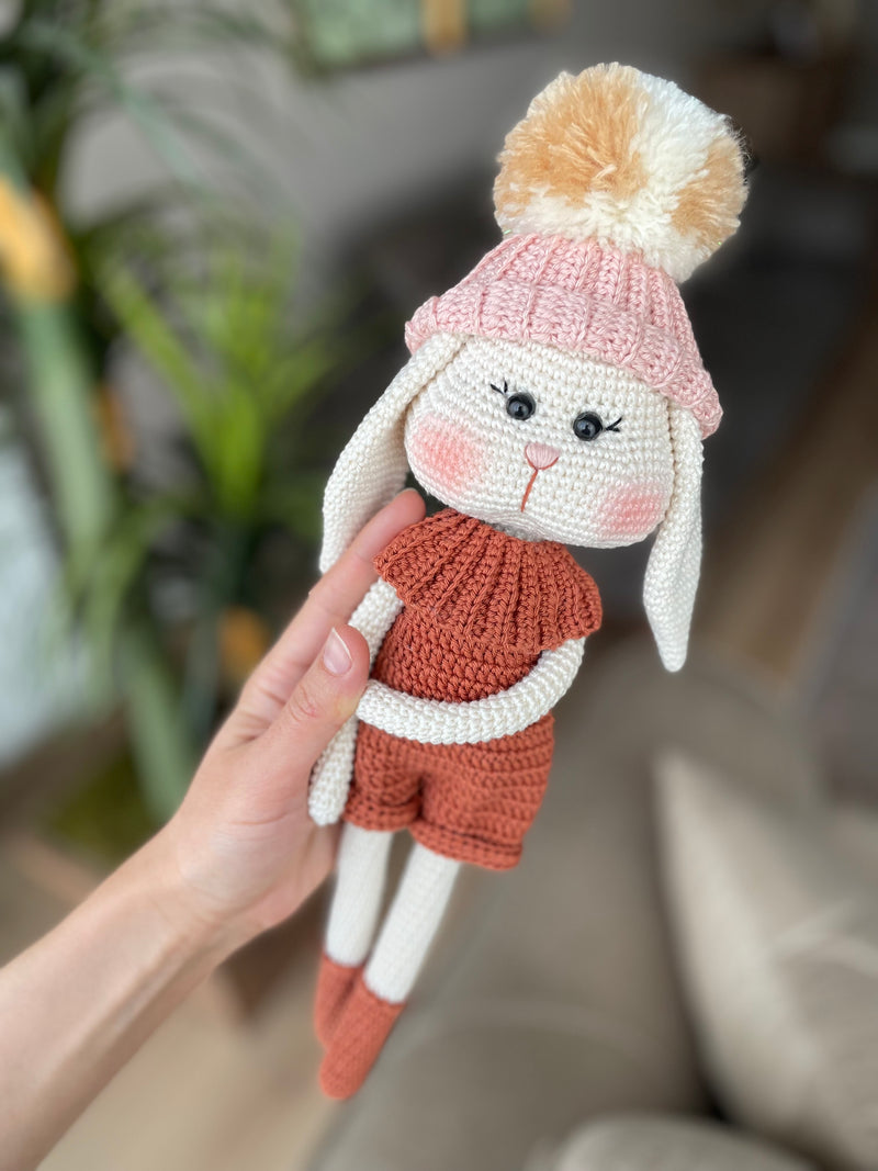 Handmade crocheted Hatted Bunny Rabbit Toy with a cozy hat and outfit, customizable with a name on a leather label. Perfect for nursery decor and as a unique easter or baby shower gift.