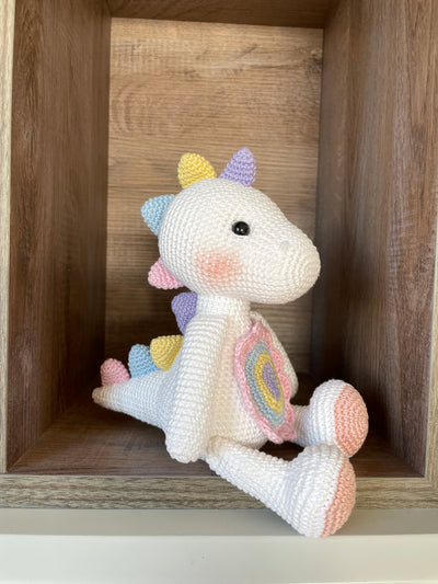 Handmade unicorn dinosaur toy crocheted with soft yarn in pastel colors, featuring customizable name on a leather label, perfect for kids and baby gifts.