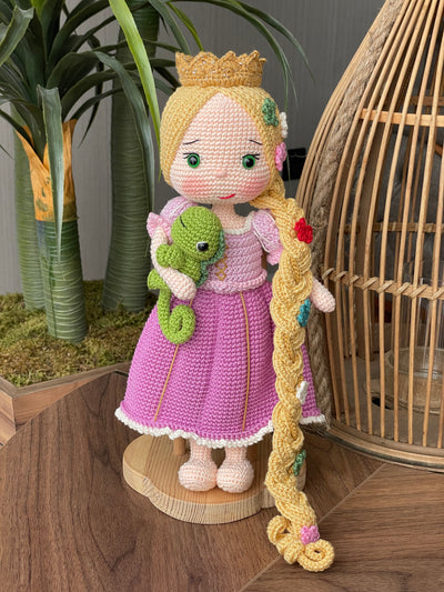 Handmade crocheted Rapunzel and Flynn Rider Dolls with Pascal, featuring intricate details such as Rapunzel's long braided hair and floral accents. These are customizable with a name on a leather label, perfect as a fairy tale-themed gift or decor.