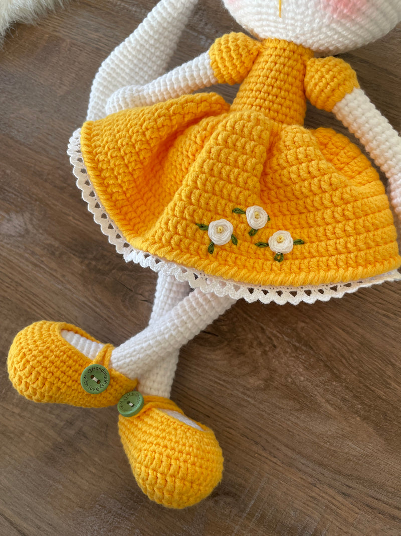 Handmade Yellow Dressed Bunny Rabbit Toy crocheted with amigurumi technique, featuring a cute yellow dress with embroidered flower details and customizable name on a leather label. Perfect for kids and baby gifts.