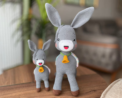 Handmade crochet Donkey Toy set, featuring a pair of amigurumi donkeys with detailed expressions, customized with a name on a leather label. Perfect gift for kids.