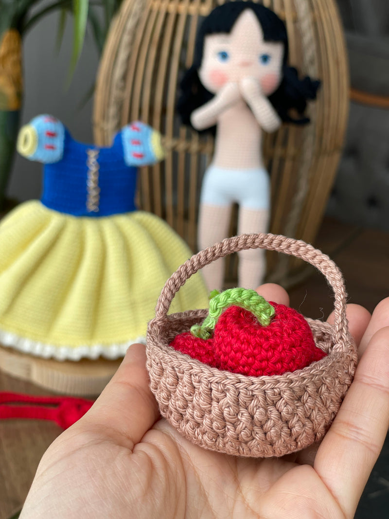 Handmade Snow White Doll wearing a classic yellow dress with a blue bodice, holding a basket of apples, made with 100% cotton yarn, customizable with a name on a leather label.