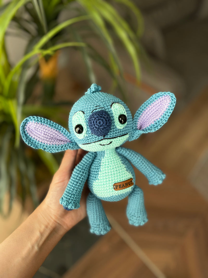 Handmade crochet Stitch Toy, amigurumi plush with a custom name on a leather label. Perfect as a personalized gift for kids, featuring a blue alien design.