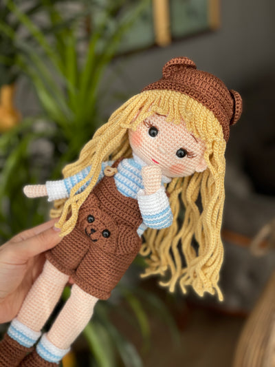 Handmade overall girl doll, crocheted using the amigurumi technique, dressed in overalls and personalized with a name on a leather label, perfect for gifts and decor.