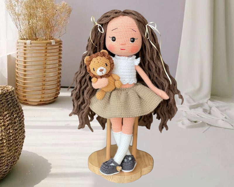 Handmade crocheted Khaki Green Skirted Olivia Doll with long brown hair, a cute skirt, and a tiny lion, customizable with a name on a leather label. Ideal for nursery decor and as a personalized gift.