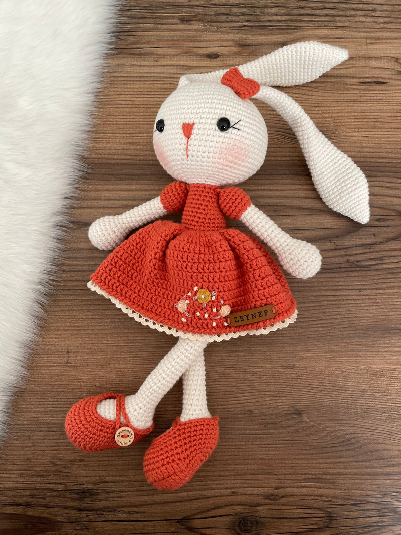 Handmade Brick Dressed Bunny Rabbit Toy crocheted with amigurumi technique, featuring a cute brick color dress with embroidered flower details and customizable name on a leather label. Perfect for kids and baby gifts.