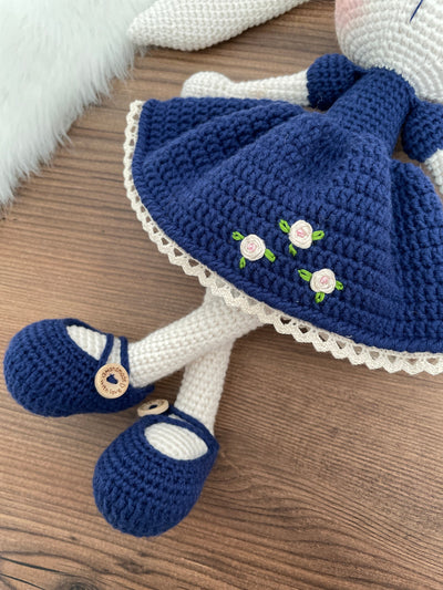 Handmade Navy Blue Dressed Bunny Rabbit Toy crocheted with amigurumi technique, featuring a cute navy blue dress with embroidered flower details and customizable name on a leather label. Perfect for kids and baby gifts.