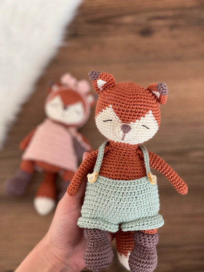 Handmade crochet Fox Couple Toy set featuring a pair of amigurumi foxes dressed in cute outfits, customized with a name on a leather label. Perfect for gifting.