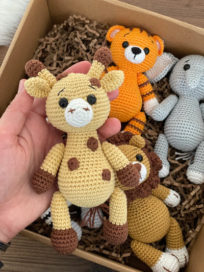 Handmade Safari Animals set including giraffe, tiger, elephant, zebra, and lion, all made with 100% cotton yarn, perfect for unique toddler gifts and imaginative play. All of them lying inside a gift box.