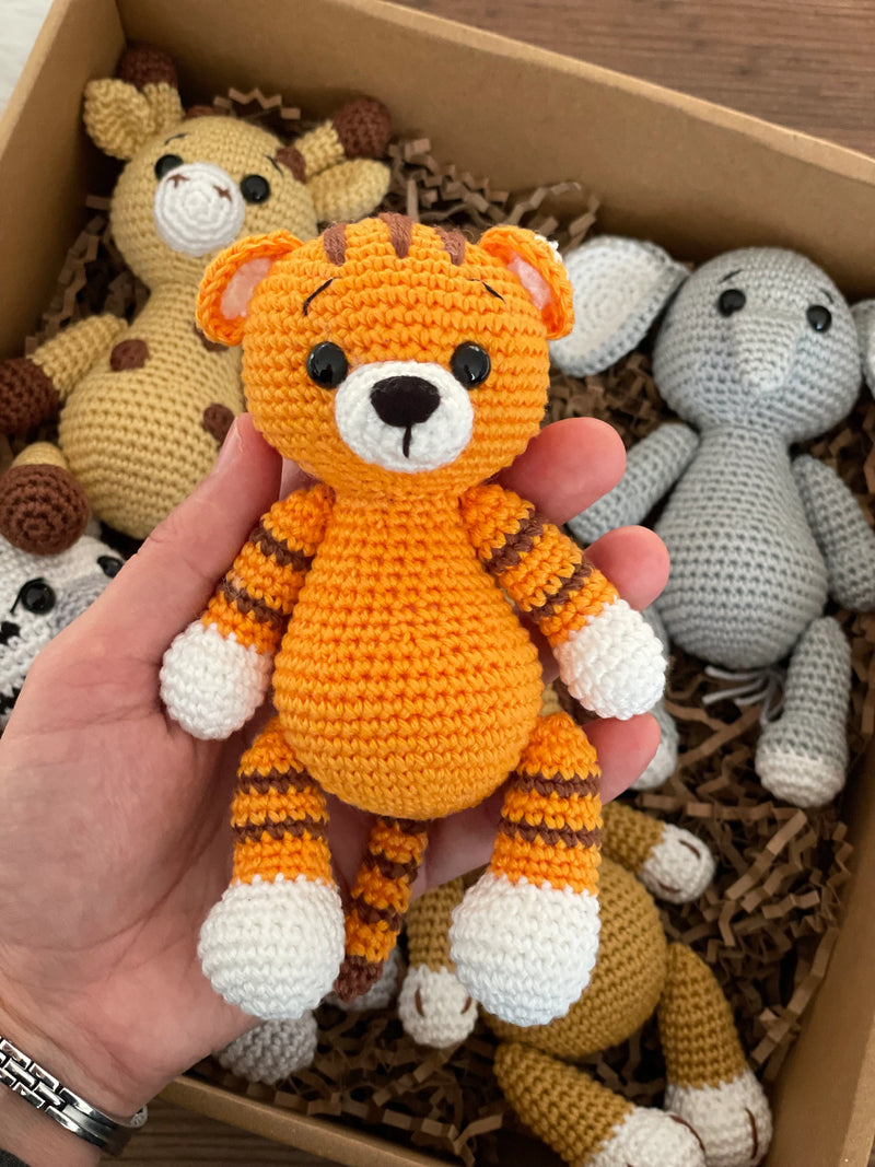 Handmade Safari Animals set including giraffe, tiger, elephant, zebra, and lion, all made with 100% cotton yarn, perfect for unique toddler gifts and imaginative play. All of them lying inside a gift box.