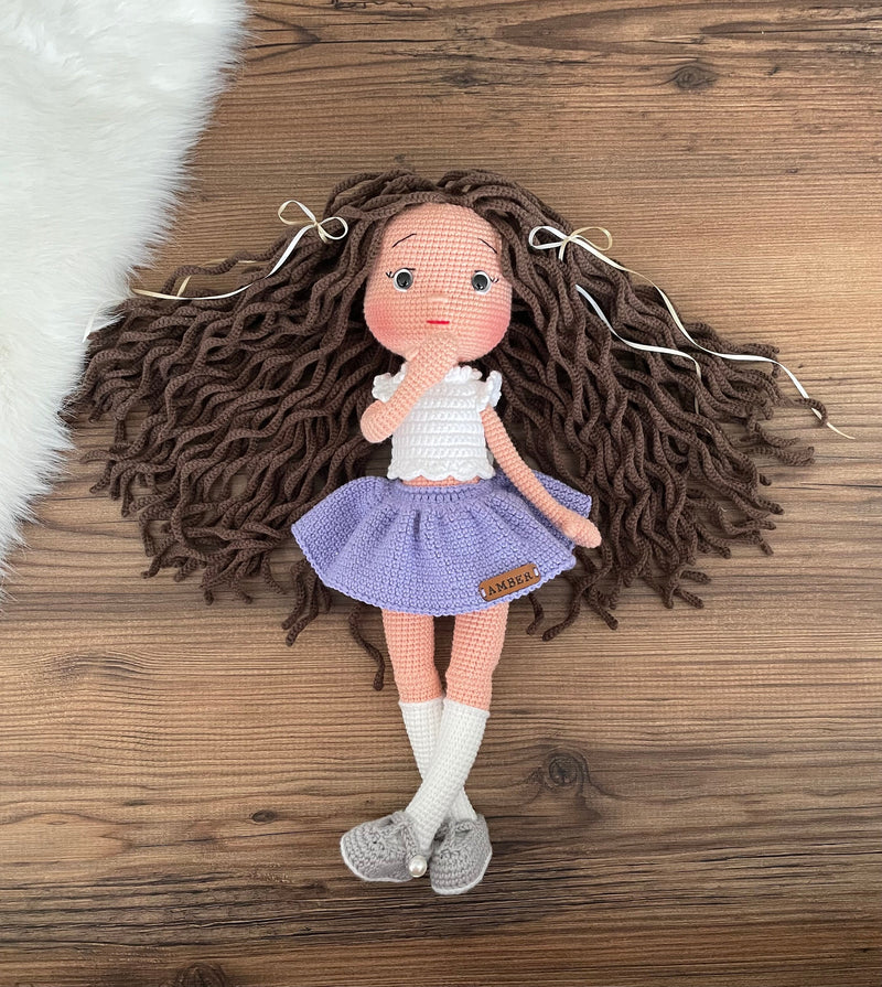 Handmade crocheted Lilac Skirted American Doll with long brown hair, a cute skirt, customizable with a name on a leather label. Ideal for nursery decor and as a personalized gift.