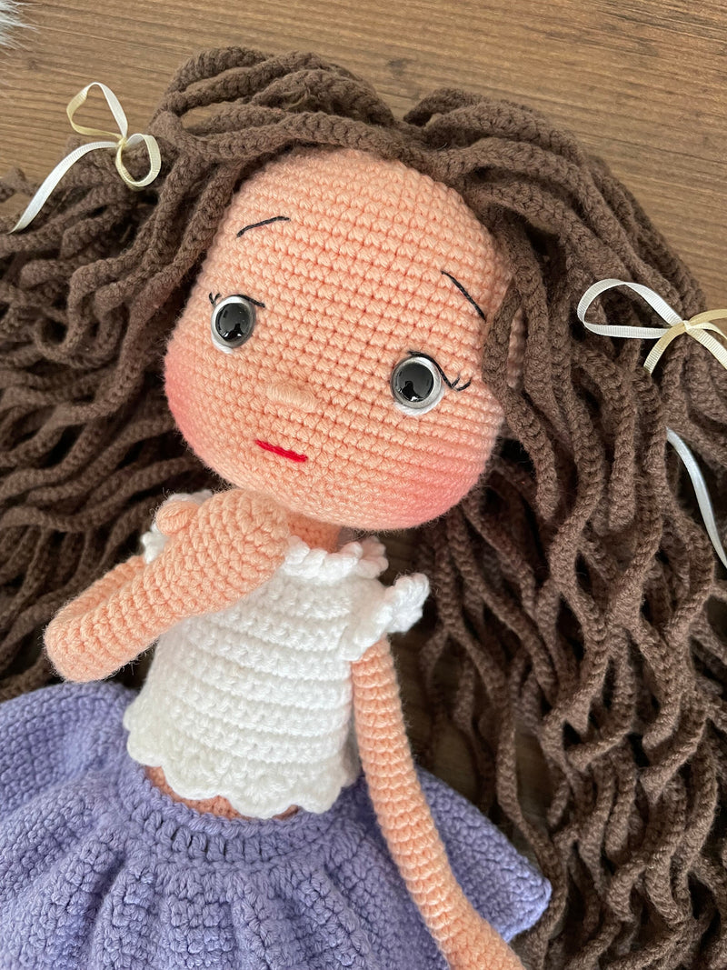 Handmade crocheted Lilac Skirted American Doll with long brown hair, a cute skirt, customizable with a name on a leather label. Ideal for nursery decor and as a personalized gift.