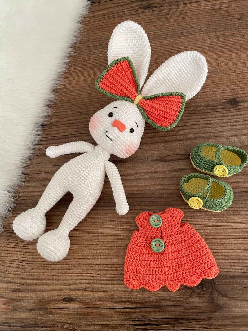 Handmade crocheted Orange Fancy Bunny Rabbit Toy in a bright orange dress with a large bow, customizable with a name on a leather label. Made using amigurumi techniques, this cute bunny is perfect for kids, nursery decor, or as a personalized gift.