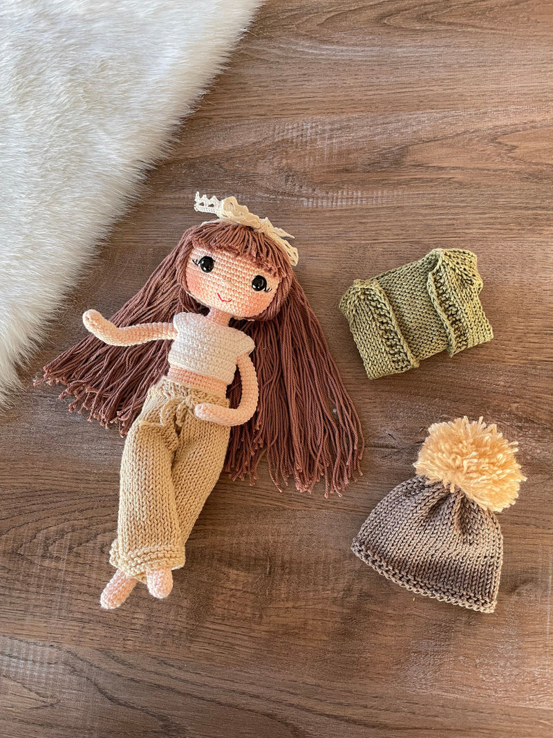 A handcrafted Green Cardigan Cool Girl Doll with long brown hair, wearing a stylish green cardigan and beanie, crocheted using the amigurumi technique, and personalized with a custom name on a leather label.