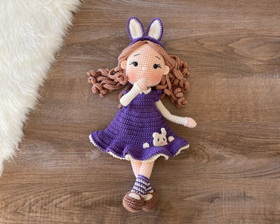 Handmade Purple Bunny Girl Doll with bunny ears, wearing a purple dress with bunny details, made with 100% cotton yarn, customizable with a name on a leather label, perfect for unique girl gifts and imaginative play.