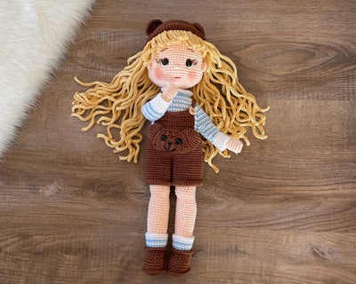 Handmade overall girl doll, crocheted using the amigurumi technique, dressed in overalls and personalized with a name on a leather label, perfect for gifts and decor.