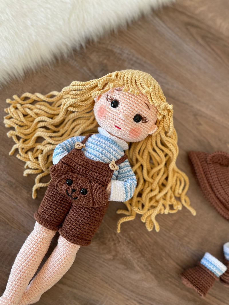 Handmade overall girl doll, crocheted using the amigurumi technique, dressed in overalls and personalized with a name on a leather label, perfect for gifts and decor.