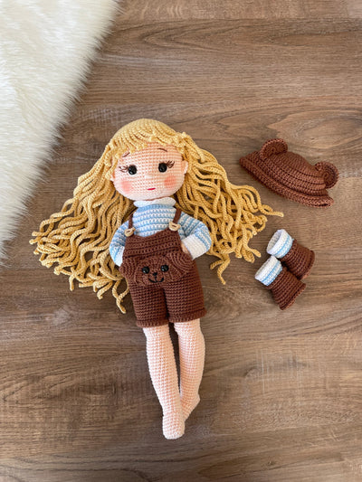 Handmade overall girl doll, crocheted using the amigurumi technique, dressed in overalls and personalized with a name on a leather label, perfect for gifts and decor.