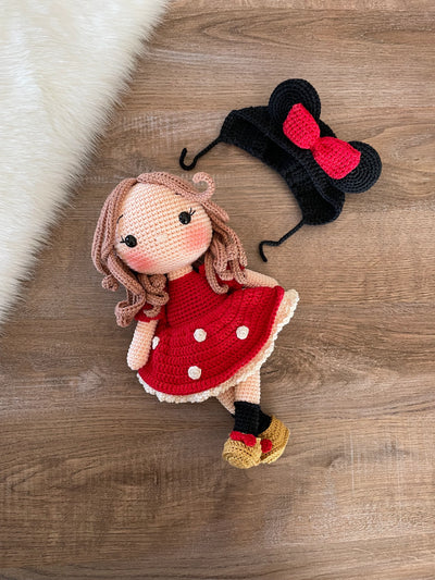 Handmade crochet Micky Girl Doll with a red dress, black ears, and a red bow. This amigurumi doll is customizable with a name on a leather label, perfect for personalized gifts.